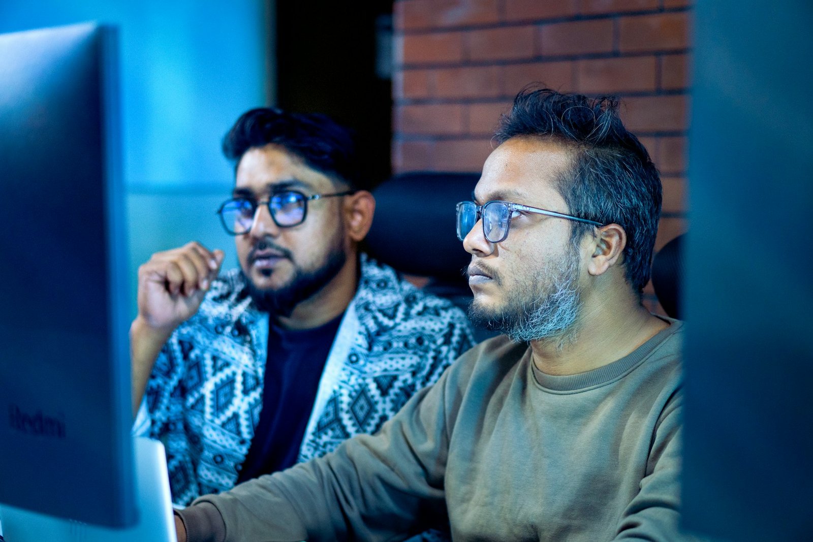 IT engineers reviewing systems on a monitor