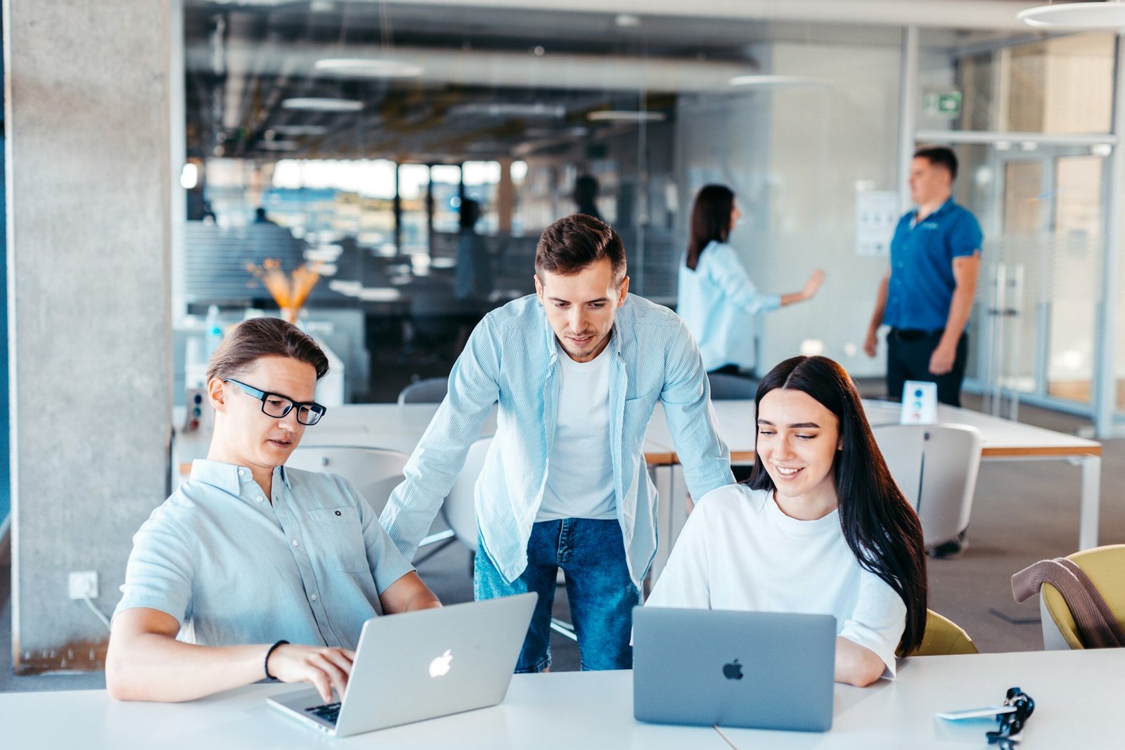 Team collaborating on laptops in a modern office